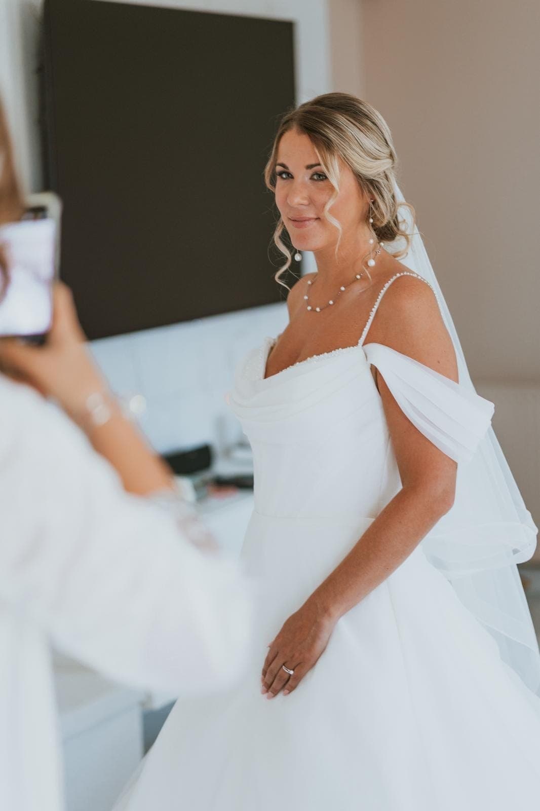 La mariée admire sa coiffure dans le miroir avant d'entrer en cérémonie