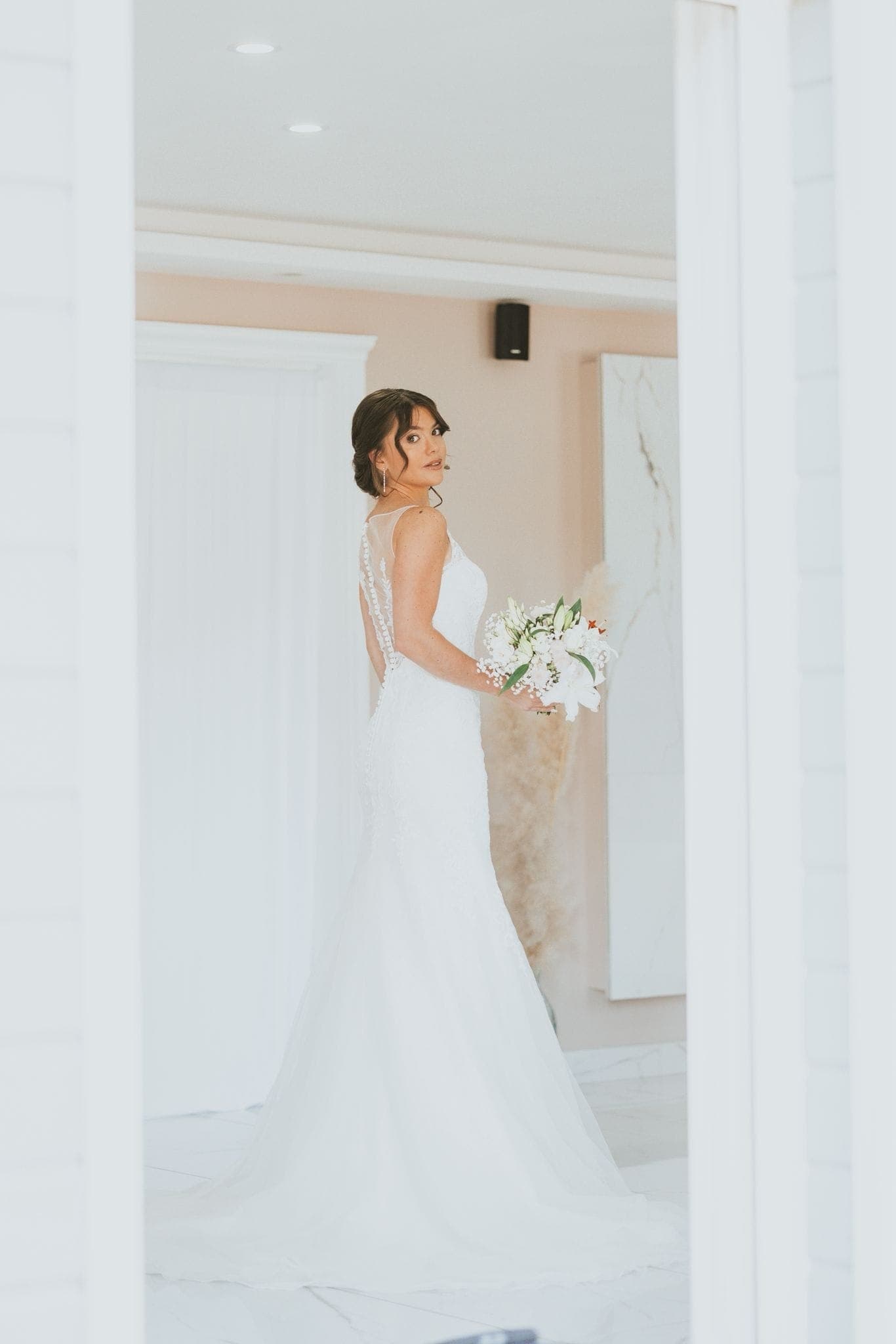 Dernier regard avant d'entrer en cérémonie, bouquet à la main, chignon romantique