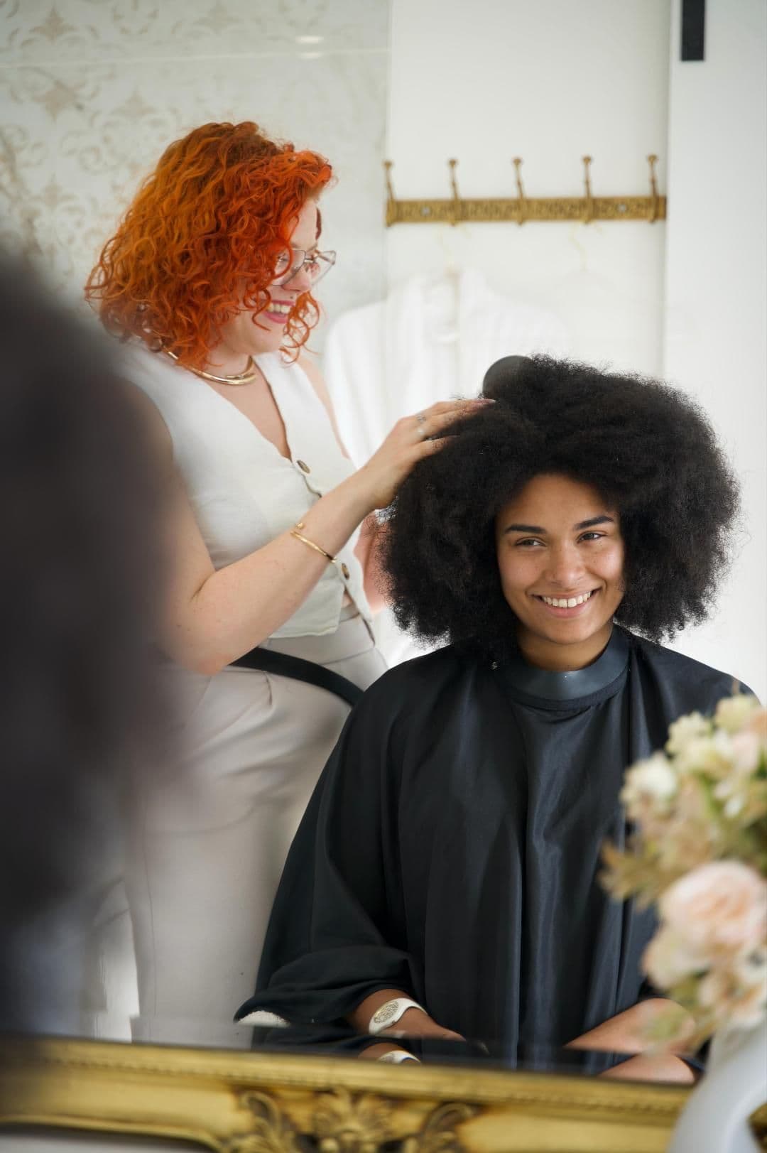 Camille coiffe une cliente aux cheveux afro avant un événement