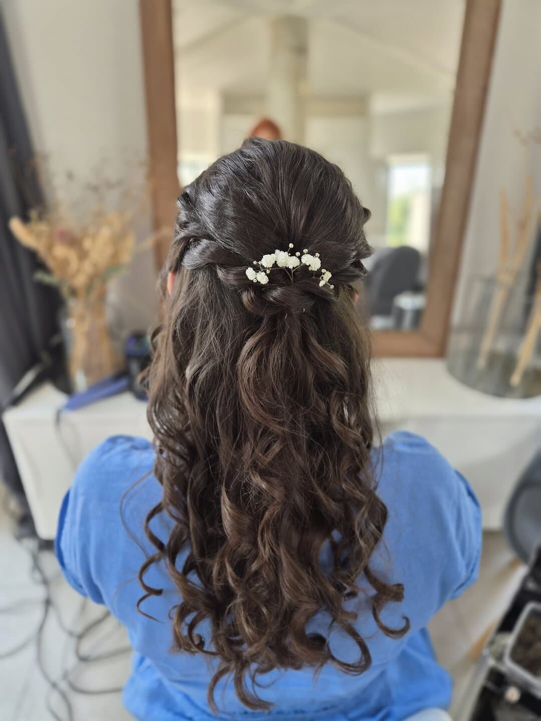 Coiffure semi-attachée ornée de fleurs, boucles souples